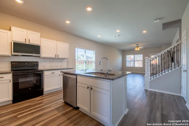 a kitchen with stainless steel appliances granite countertop a stove a sink and a microwave