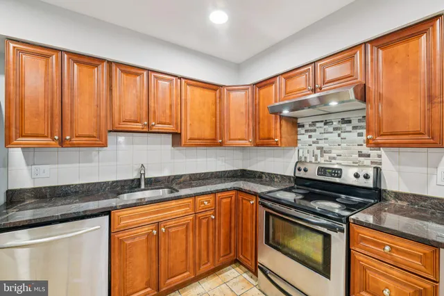 a kitchen with stainless steel appliances granite countertop a sink stove and cabinets