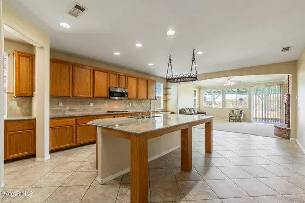 a kitchen with stainless steel appliances granite countertop a stove top oven a sink dishwasher and a refrigerator with cabinets