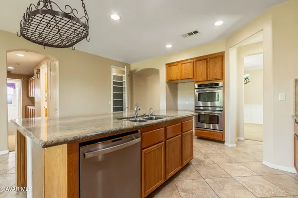 a kitchen with stainless steel appliances granite countertop a sink and a refrigerator
