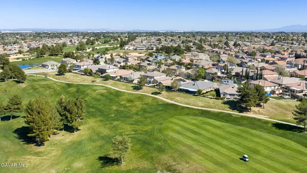 an aerial view of residential houses with outdoor space and trees