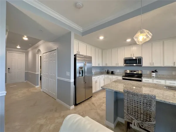 a kitchen with stainless steel appliances granite countertop a refrigerator stove microwave and sink