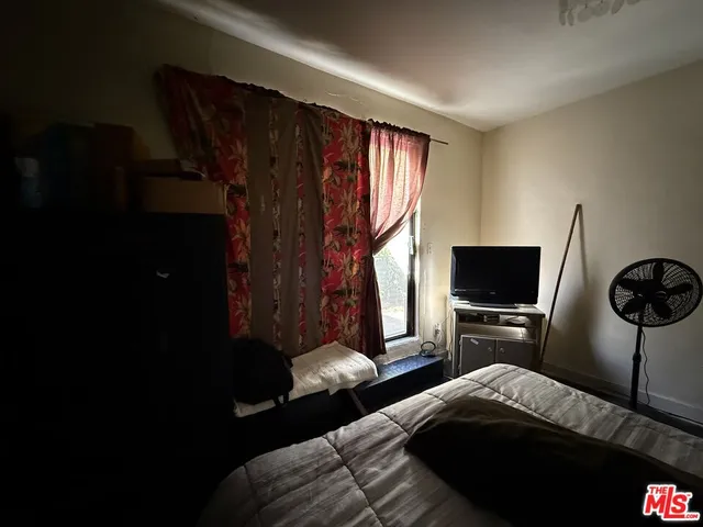 a bedroom with a bed and a flat tv screen
