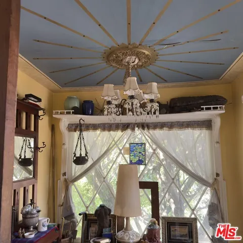 a view of a living room with a chandelier fan and wooden floor
