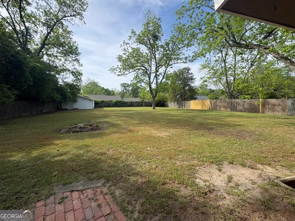 a view of a green field with wooden fence