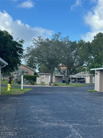 a view of a house with a yard and a large tree