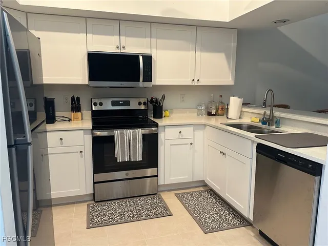a kitchen with stainless steel appliances a stove a sink and a microwave