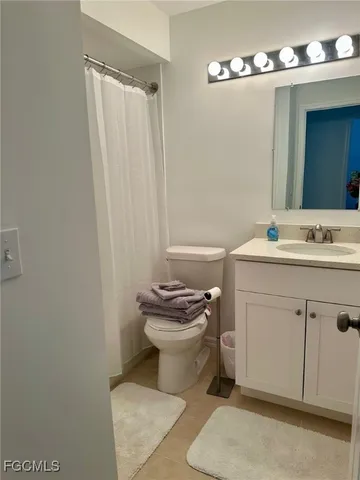 a bathroom with a sink a toilet a mirror and shower