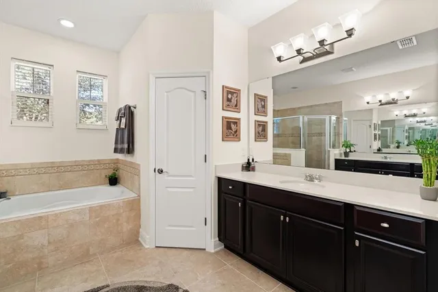 a spacious bathroom with a tub sink and mirror
