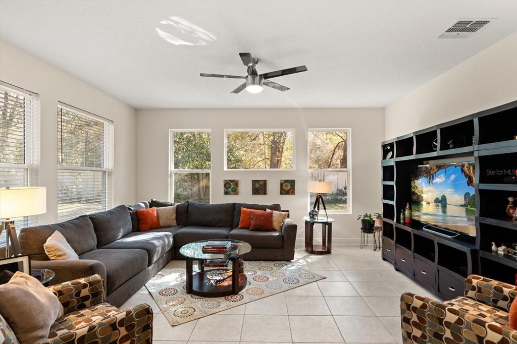 2709 Tree Meadow Loop Apopka, FL 32712 - Photo 5 of 31 a living room with furniture a flat screen tv and a large window