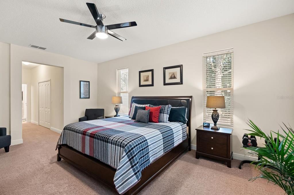 2709 Tree Meadow Loop Apopka, FL 32712 - Photo 9 of 31 a bedroom with a bed a ceiling fan and a dresser