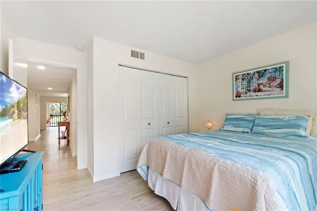 a bedroom with a bed and a painting on the wall