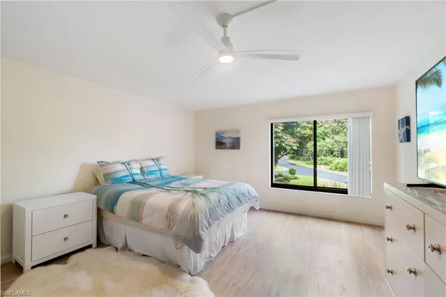 a bedroom with a bed and a large window