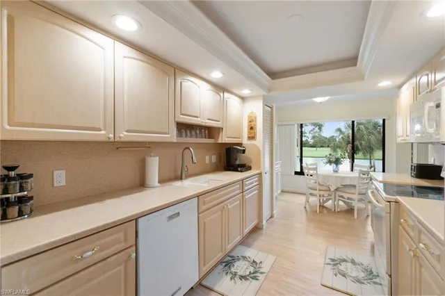 a large white kitchen with lots of counter space and windows