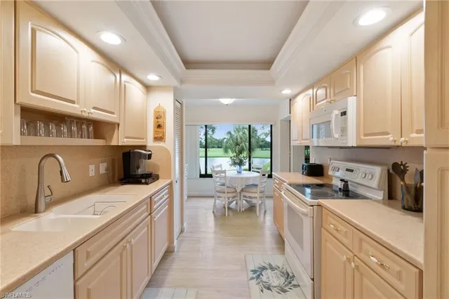 a kitchen with a sink appliances cabinets and furniture