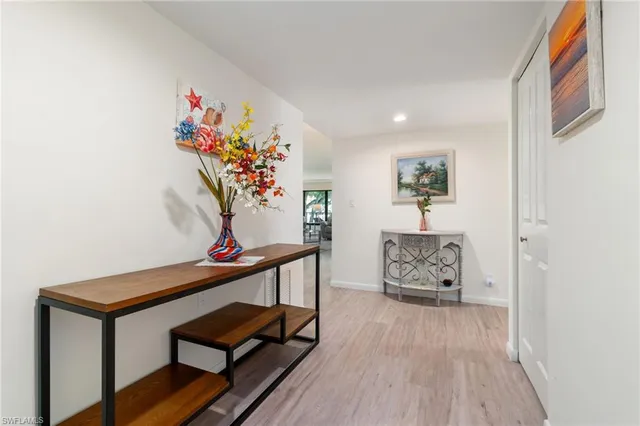 a view of a hallway with wooden floor and furniture
