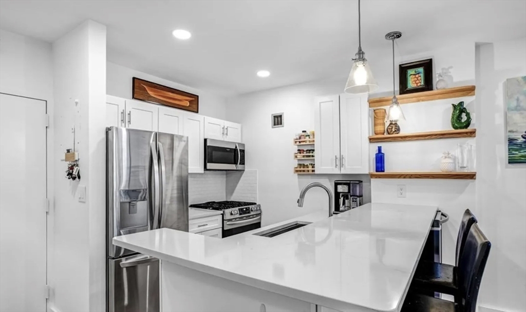 42 8th Street, Unit 3103 Boston, MA 02129 - Photo 1 of 11 a kitchen with stainless steel appliances a refrigerator a stove a sink a oven with white cabinets and wooden floor