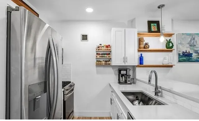 a kitchen with stainless steel appliances granite countertop a refrigerator and a sink