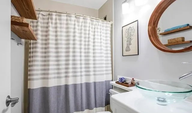 a bathroom with a sink a toilet and shower curtain