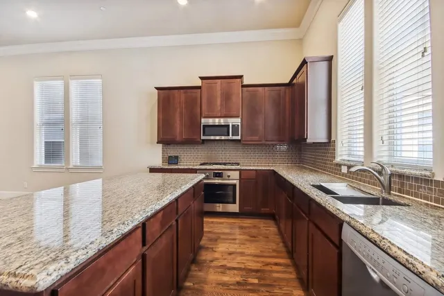 a kitchen with stainless steel appliances granite countertop a sink stove and cabinets