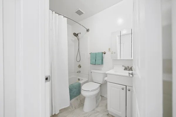 a bed room with a bed and a refrigerator