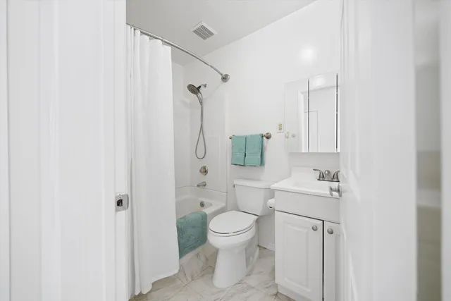 a bed room with a bed and a refrigerator