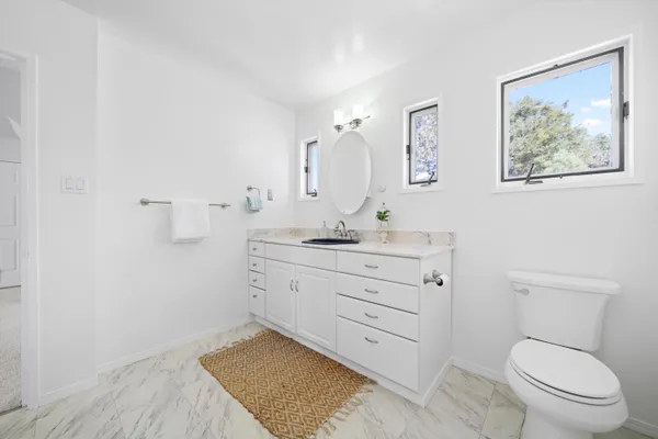 a bathroom with a sink a toilet and shower curtain