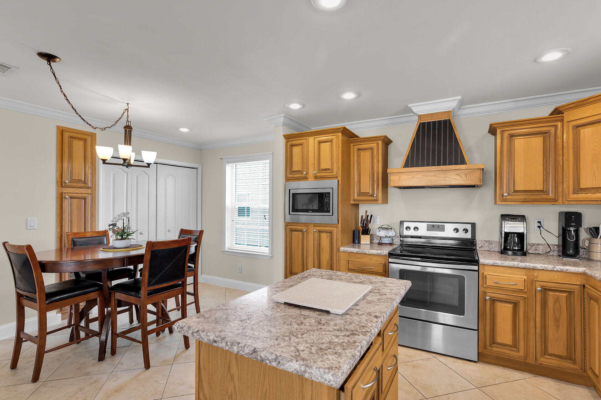 437 Pirates Road Summerland Key, FL 33042 - Photo 17 of 39 a kitchen with granite countertop kitchen island stainless steel appliances a stove a sink a dining table and chairs