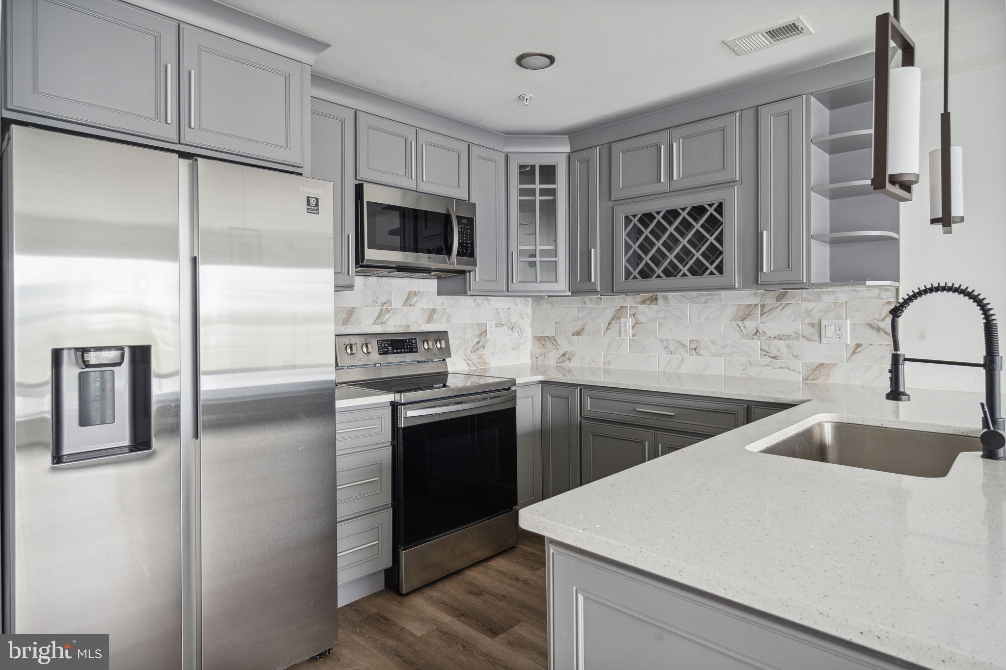 1930 North 2nd Street, Unit 2A Philadelphia, PA 19122 - Photo 6 of 23 a kitchen with stainless steel appliances granite countertop a refrigerator sink and stove
