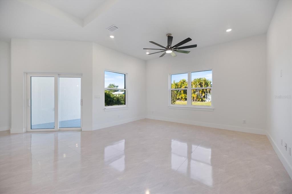 482 Sunset Road North Rotonda West, FL 33947 - Photo 11 of 45 an empty room with windows and ceiling fan