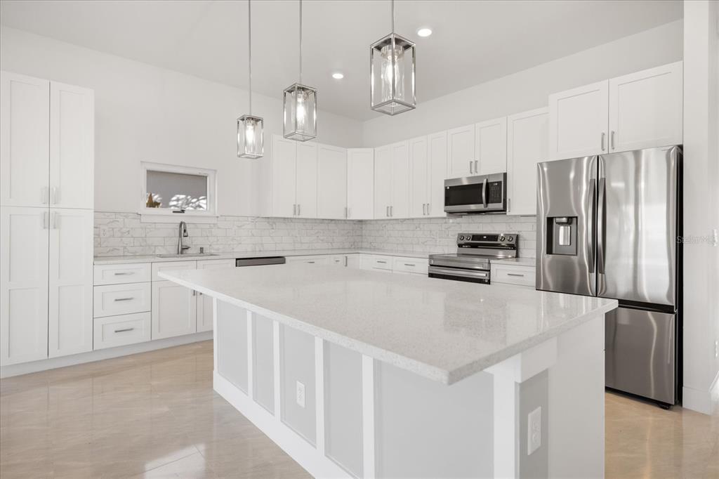 482 Sunset Road North Rotonda West, FL 33947 - Photo 15 of 45 a kitchen with stainless steel appliances a refrigerator sink and microwave