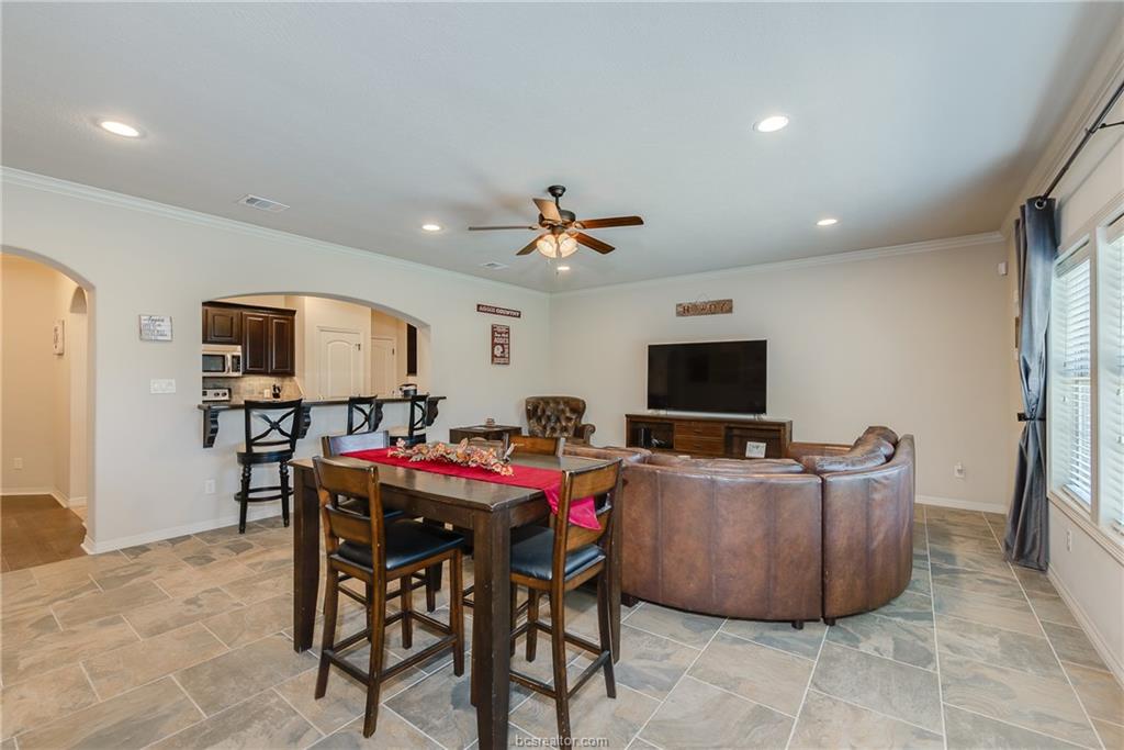 1408 Cres Ridge Drive College Station, TX 77845 - Photo 5 of 19 Dining space with arched walkways, light stone finish flooring, recessed lighting, ceiling fan, and crown molding