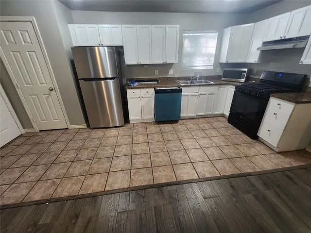a kitchen with a sink a stove top oven and refrigerator