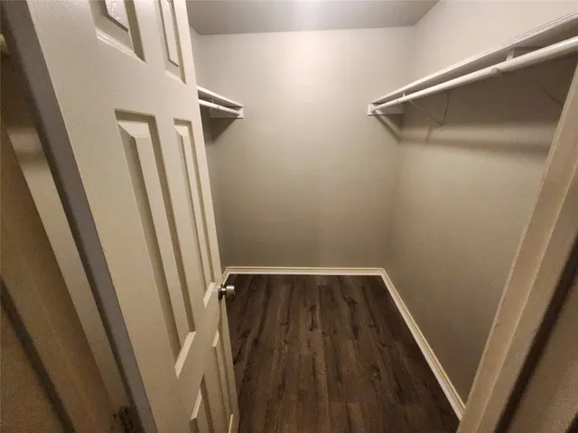 a view of walk in closet with wooden floor