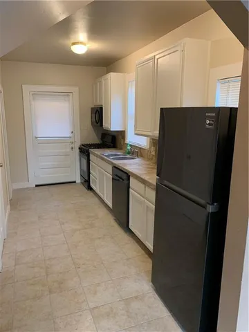 a kitchen with stainless steel appliances a refrigerator sink and cabinets