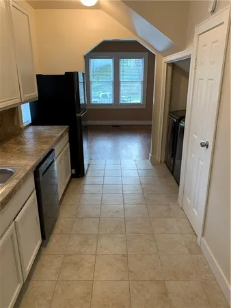 a kitchen with granite countertop a stove a sink and a refrigerator