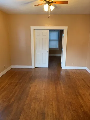 a view of an empty room with a chandelier fan