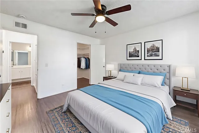 an empty room with wooden floor ceiling fan and windows