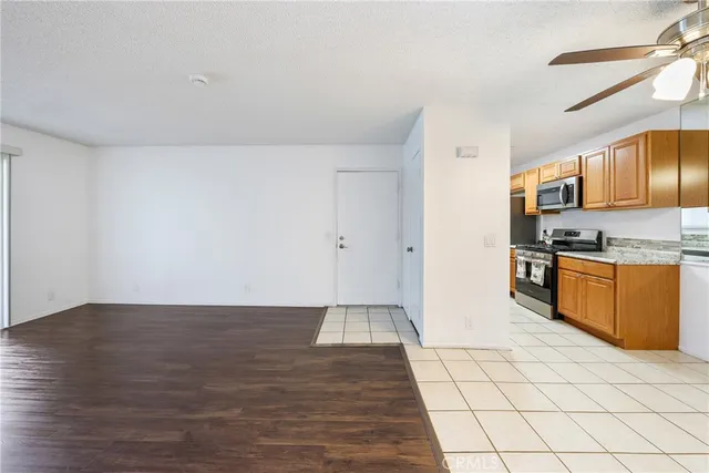 a view of kitchen with microwave refrigerator and cabinets