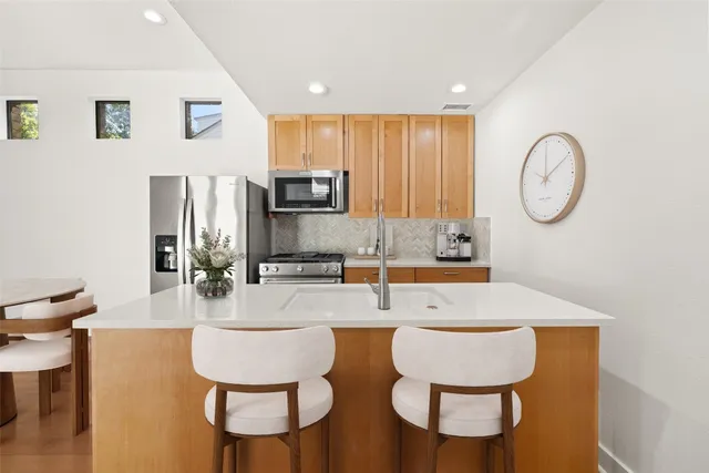 a large white kitchen with lots of counter space and furniture
