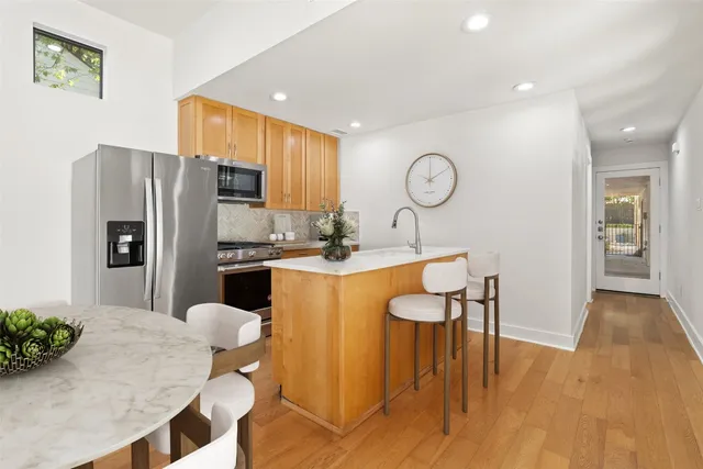 a kitchen with a dining table chairs and a refrigerator
