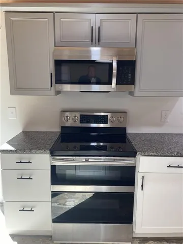a stove top oven sitting inside of a kitchen and granite counter tops