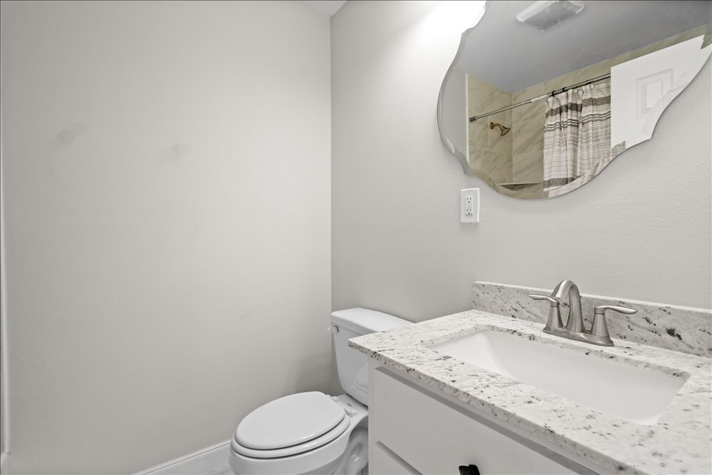 608 Whistleville Road Flatonia, TX 78941 - Photo 12 of 26 This is the secondary bathroom that features a matching granite-top vanity and a clean white cabinet, perfect for guests.
