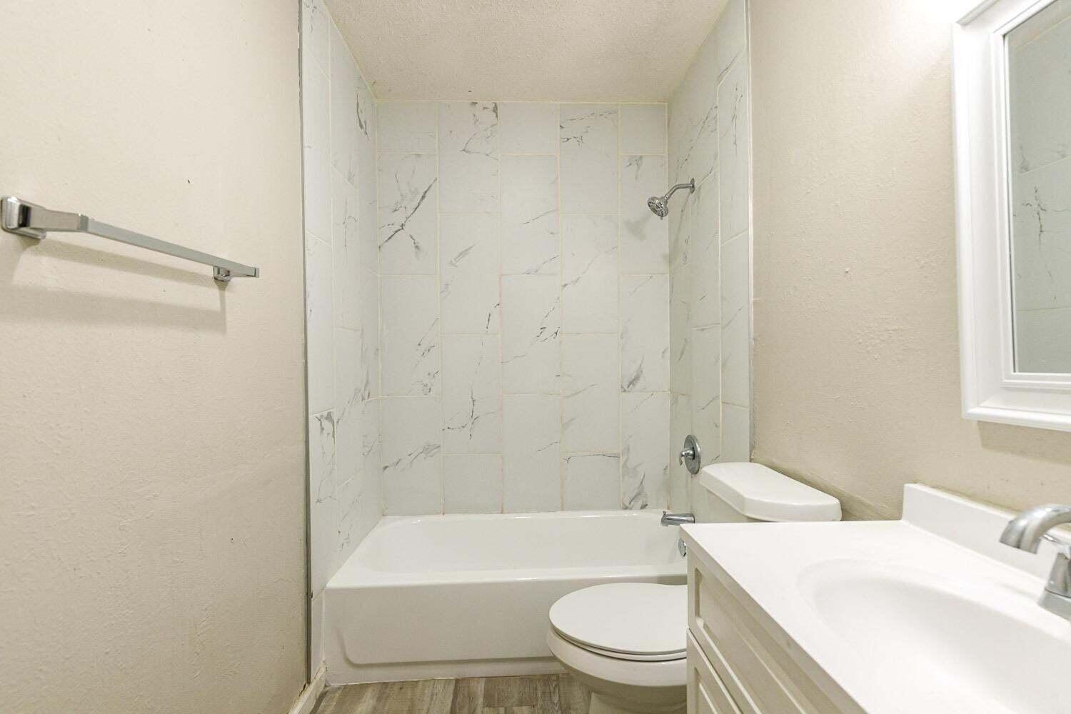 4634 Fordham Street Lubbock, TX 79416 - Photo 13 of 13 a bathroom with a toilet a sink and a bathtub