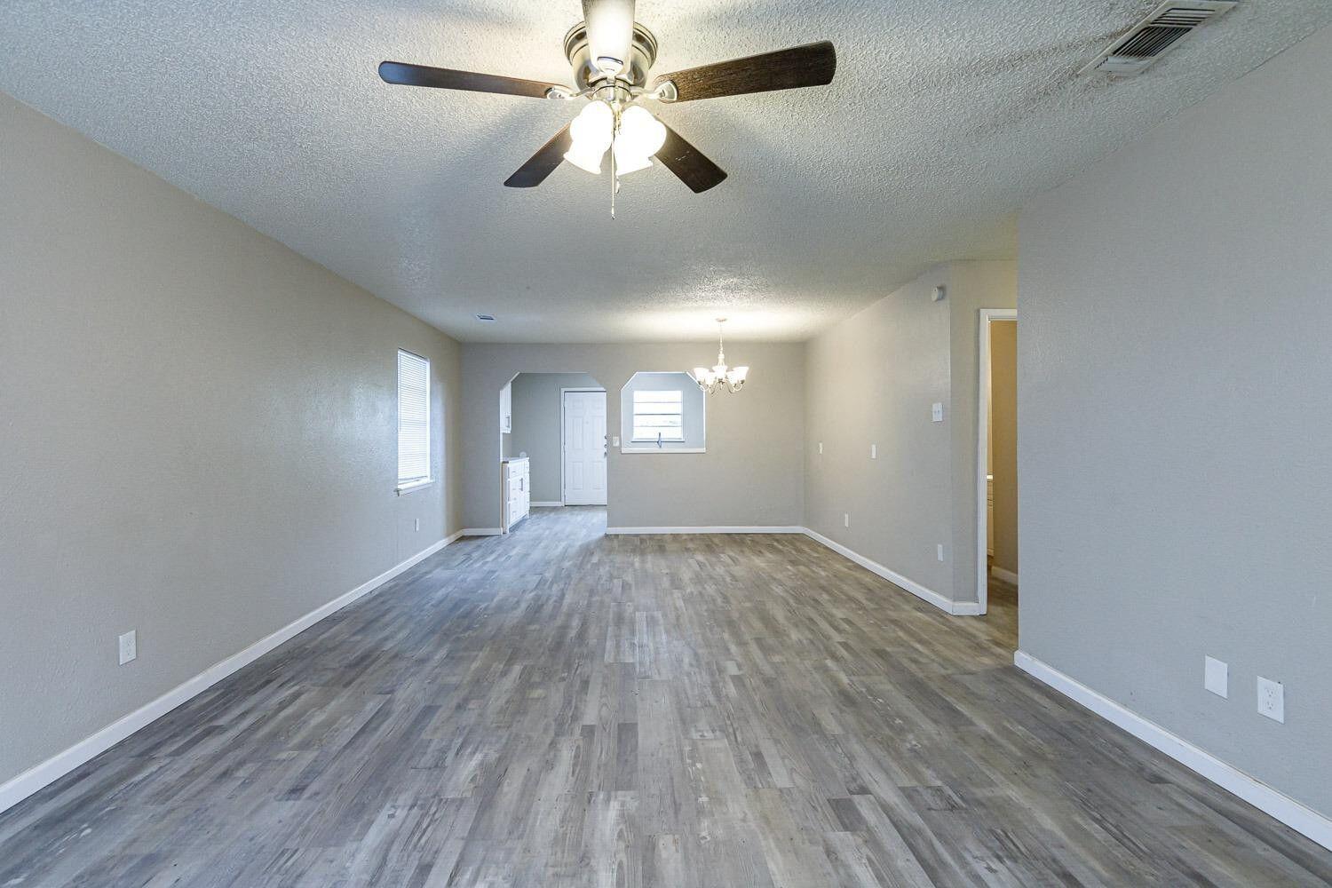 4634 Fordham Street Lubbock, TX 79416 - Photo 4 of 13 wooden floor in an empty room with a window
