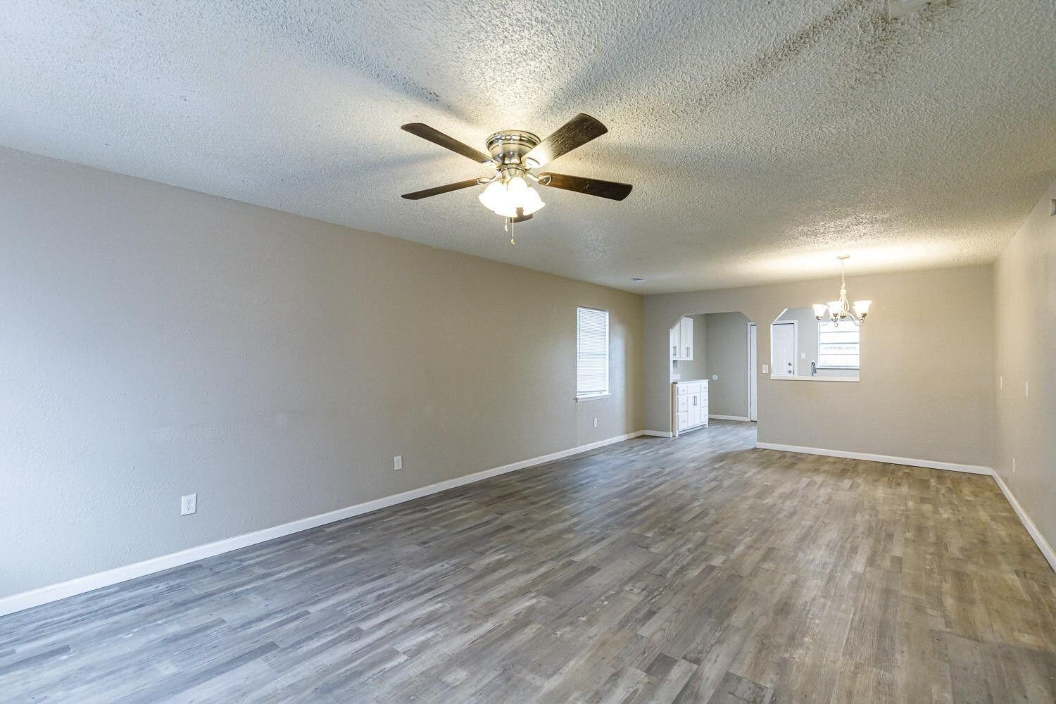 4634 Fordham Street Lubbock, TX 79416 - Photo 5 of 13 a view of a livingroom with a window and a ceiling fan