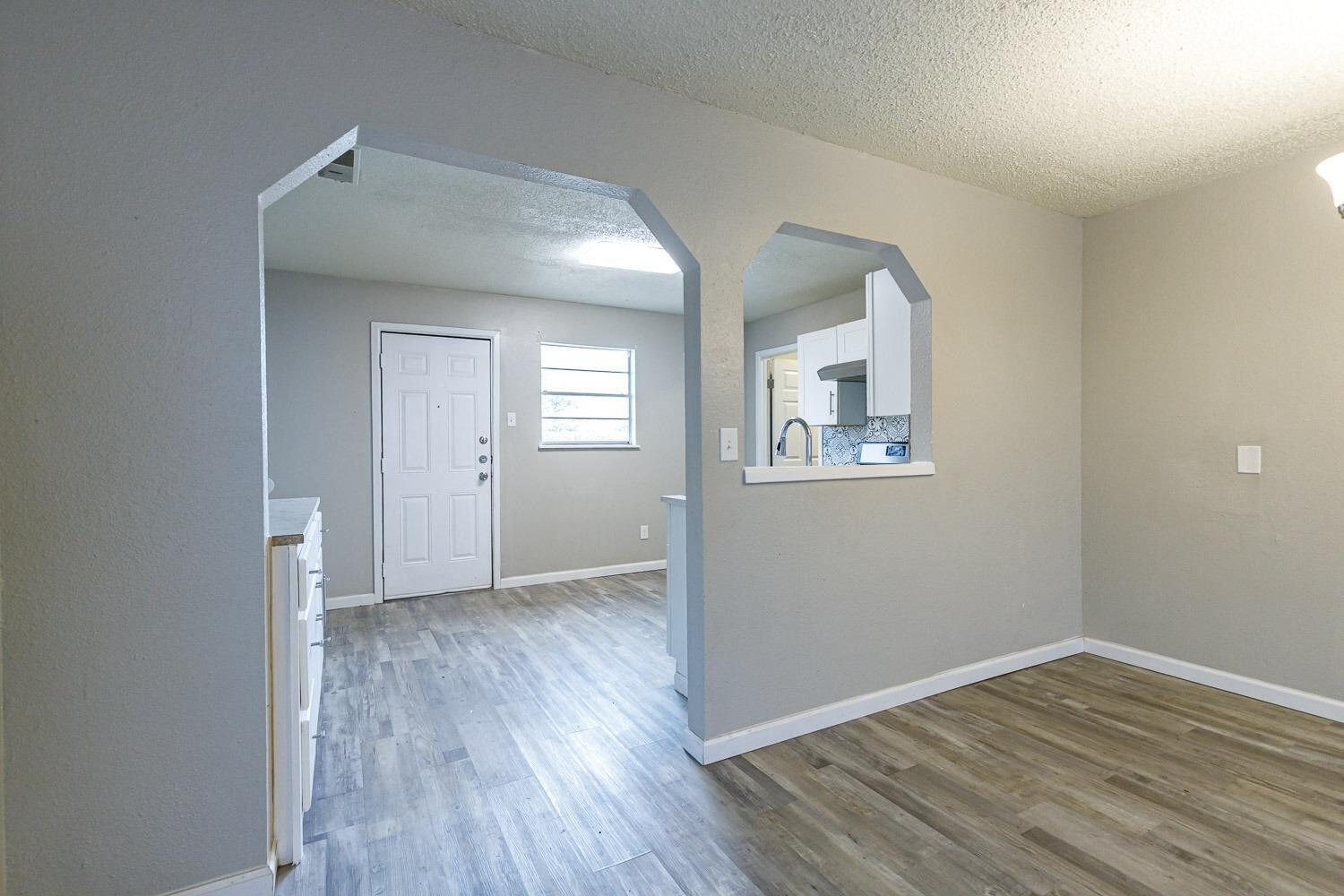 4634 Fordham Street Lubbock, TX 79416 - Photo 6 of 13 an empty room with wooden floor and windows