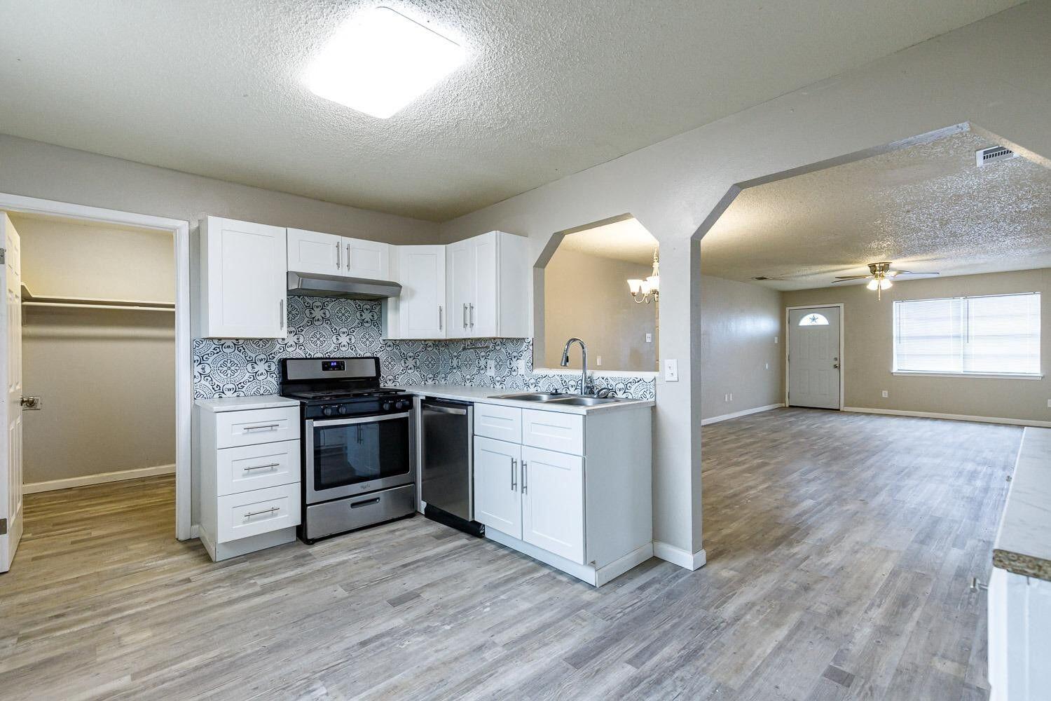 4634 Fordham Street Lubbock, TX 79416 - Photo 7 of 13 a kitchen with a refrigerator stove and wooden floor