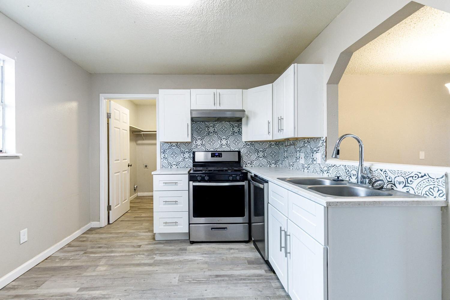 4634 Fordham Street Lubbock, TX 79416 - Photo 8 of 13 a kitchen with stainless steel appliances granite countertop a sink stove and refrigerator