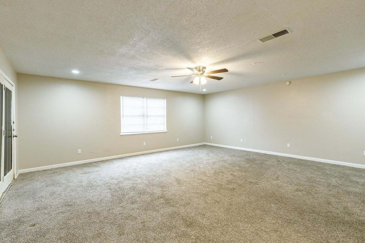 4634 Fordham Street Lubbock, TX 79416 - Photo 10 of 13 an empty room with a ceiling fan and window